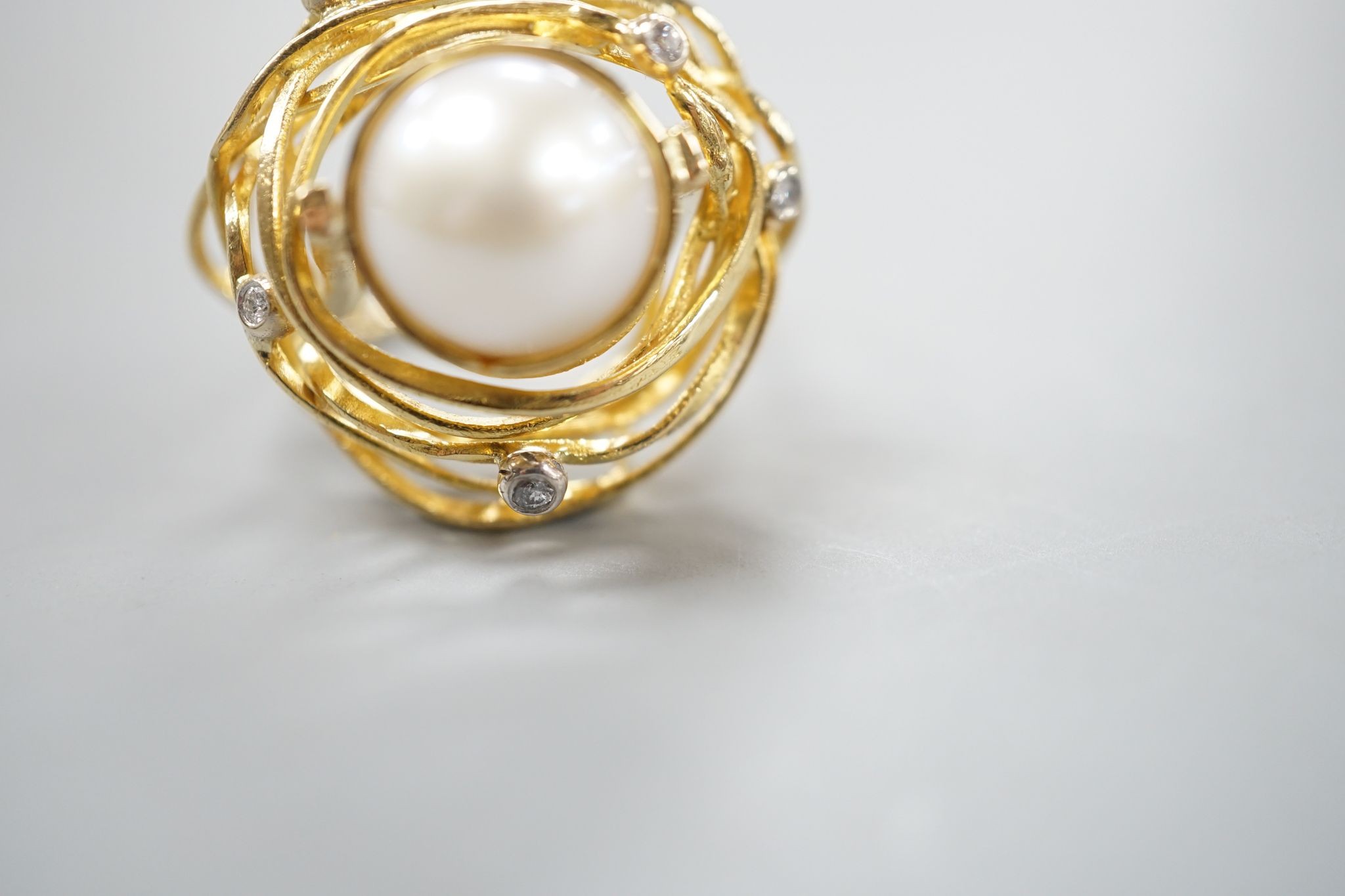 A modern 750 yellow metal, mabe pearl and diamond chip set modernist dress ring, size Q, gross 13.2 grams.